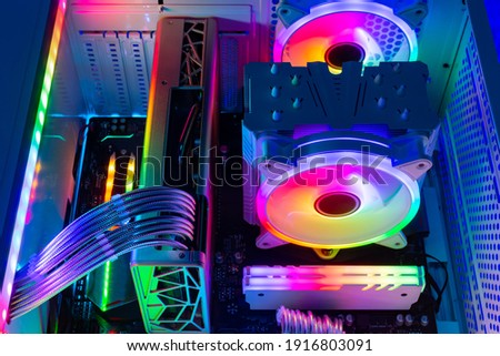 Inside view of custom colorful illuminated bright rainbow RGB LED gaming pc.. Computer power hardware and technology concept background Royalty-Free Stock Photo #1916803091