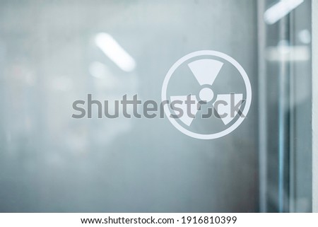 Radiation zone sign sticker on window of laboratory room. Health and safety concept Royalty-Free Stock Photo #1916810399