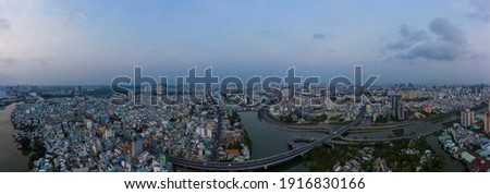 Early morning drone panorama before sunrise. The big sprawling city is waking up with traffic, bridges, main roads, off ramps and canal system of Ho Chi Minh City, vietnam
