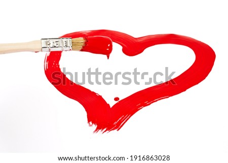 Brush with red paint drawing a heart