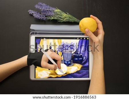 A girl in a special glove draws a still life picture with a pencil on an electronic tablet. The concept of inspiration, creativity, self-development, hobby, modern art
