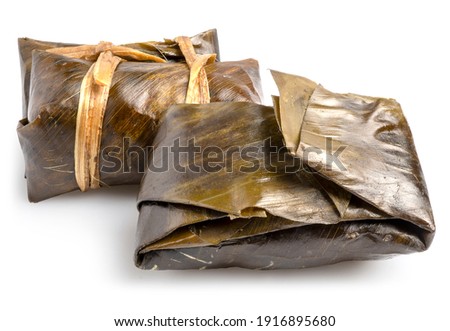 Khao Tom Mud or Khao Tom Pad, Traditional Thai dessert made from steamed sticky rice, coconut milk, banana and black beans wrapped in banana leaves, isolated in white background. Clipping path