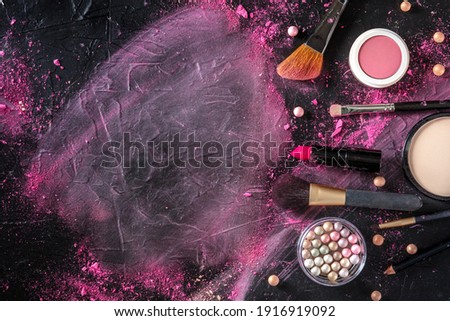 Makeup brushes, pearls and other products, shot from the top on a black background with a place for text