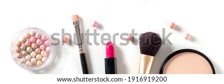 Makeup overhead flat lay panorama on a white background. Pearls, lipstick, brushes and powder