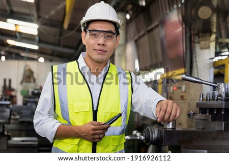 Manufacturing worker. Professional Asian worker controlling the work. Cheerful Factory Worker Posing. Royalty-Free Stock Photo #1916926112