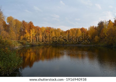 Beautiful autumn landscape with lake and colorful trees on its bank