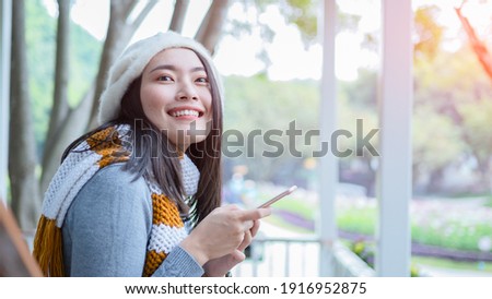 Portrait of attractive asian long black hair  too smile ,hand use smartphone  relax with background of garden  copyspace freedom and cheerful emotional .