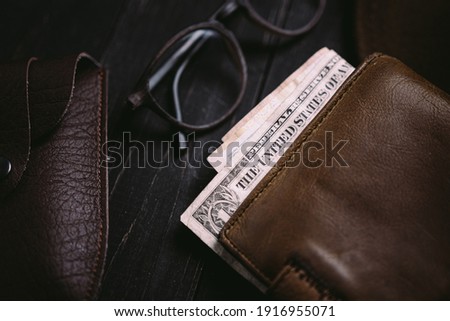 Old money bills in a vintage wallet. Flat lay of travel wooden desk