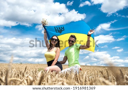 molda happy couple with flag of ukraine in wheat field. lifestyle