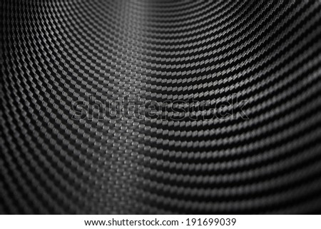 Close up shot of texture of carbon fiber tube with light reflection from the back, show detail of trellis pattern of black luxury carbon fiber. Curved texture of carbon fiber in close up look.