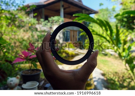 variable ND filter in hand with blured background