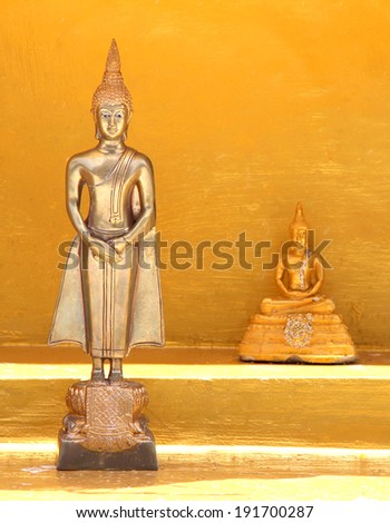 Two Buddha standing and sitting on gold background