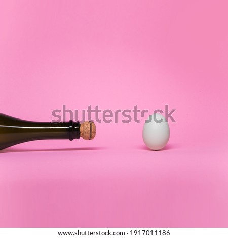 Bottle champagne and egg on pink backgroung