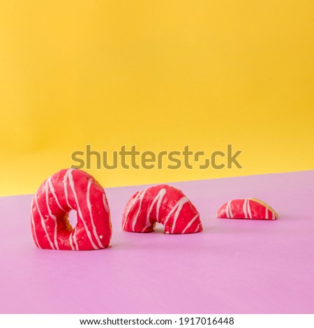 Parts of donuts alignet on pink table