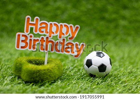 Soccer birthday with soccer ball is on green grass