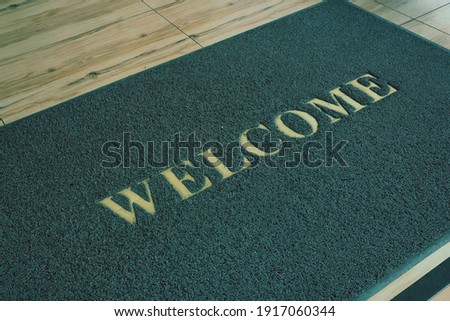 Big Welcome mat on floor.