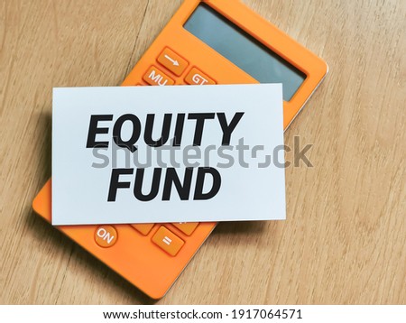 Business and finance concept. Phrase EQUITY FUND written on white card with calculator.