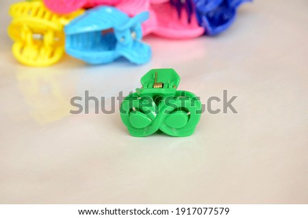 the small green plastic hair clutch er with colorful cloture isolated on white background.