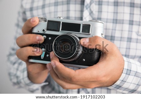 the man holding vintage camera
