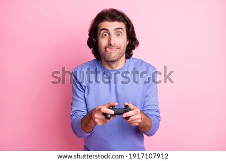 Photo of funky guy hold playstation tongue out wear purple sweater isolated on pastel pink color background