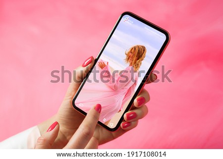 Person holding phone and looking at woman dancing in video posted on social media 