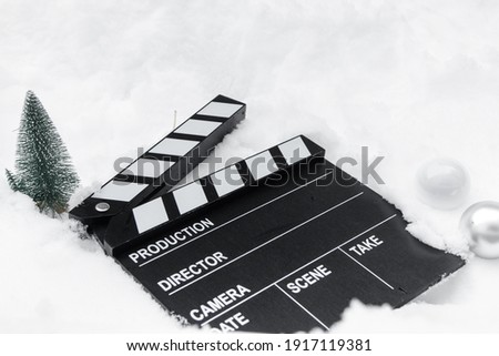Clapper board in the snow with Christmas elements