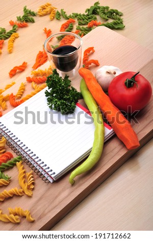 with blank recipe book ,carrots, tomatoes, green peppers 