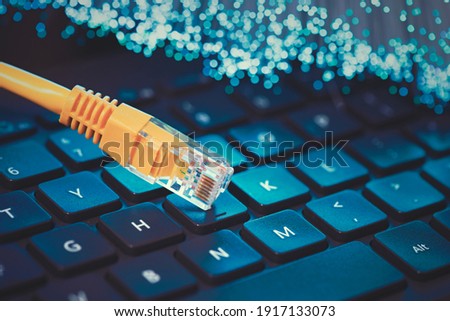 Internet cable, RJ-45 plug on laptop keyboard. High speed fiber optic internet concept Royalty-Free Stock Photo #1917133073