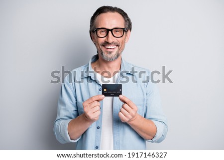 Photo of handsome businessman happy smile hold credit card money profit purchase customer isolated over grey color background