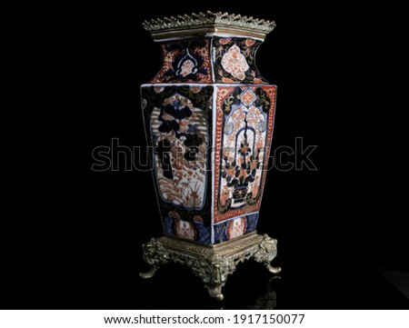 A 19th century Japanese Meiji period Imari square form, baluster vase. Painted with prunus in a landscape and flowering censers. Fitted with pierced and tooled gilt metal mounts on a black background