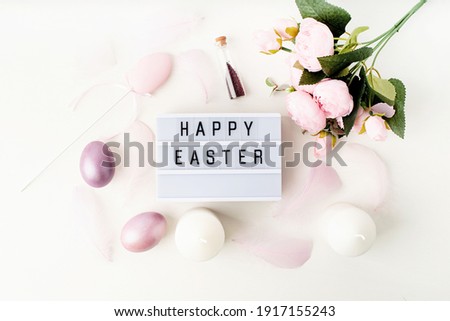 Easter holiday. Top view Happy Easter light box decorated with pastel colored eggs and feathers