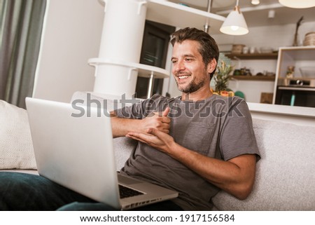 Young man showing gesture in sign language using laptop, make video call.