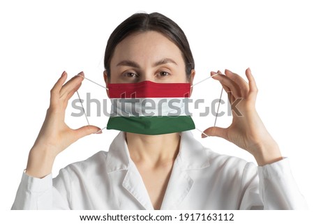 Respirator with flag of Hungary Doctor puts on medical face mask isolated on white background.