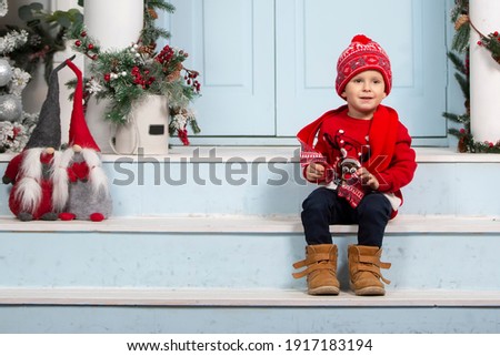 Happy little boy in christmas. Funny child on the porch of the Christmas house.