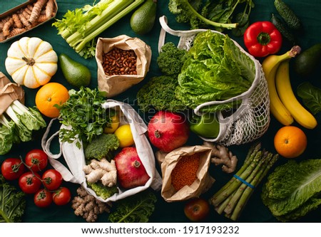 Freshly delivered locally grown fruits and vegetables packed in eco-friendly paper bags or textile shopping bags, zero waste vegetarian nutrition concept Royalty-Free Stock Photo #1917193232