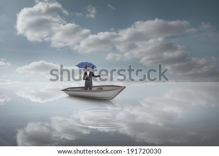 Composite image of peaceful businessman holding blue umbrella in a sailboat in peaceful water and sky