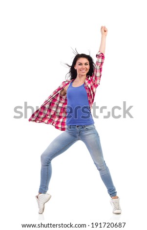 Ecstatic female dancer posing and punching the air. Full length studio shot isolated on white.