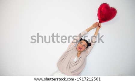 Love concept. Woman flying away with red heart balloon on a white background.