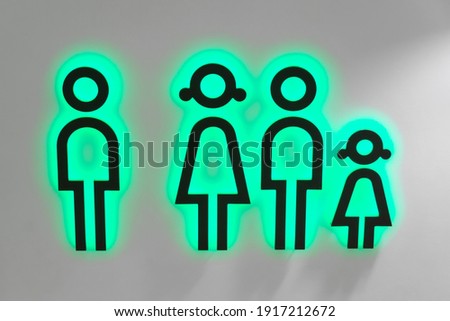 Male and female toilet sign, with neon green illumination