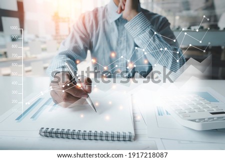 Businessmen are analyzing graphs and taking notes with charts and graphs in the office. Royalty-Free Stock Photo #1917218087