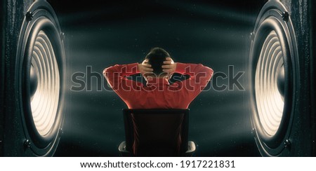 The man covers his ears from the powerful sound from the speakers. Royalty-Free Stock Photo #1917221831