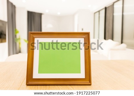 close up of photo frame with green copy space on table in living room at home