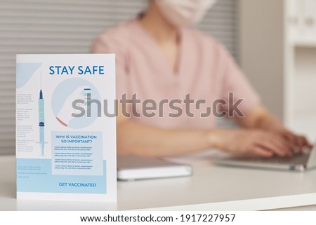 Background image of covid vaccination and safety sign at desk in doctors office, copy space