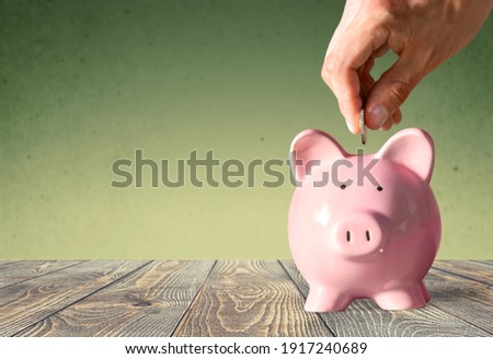 Businessman putting coin into the piggy bank Royalty-Free Stock Photo #1917240689