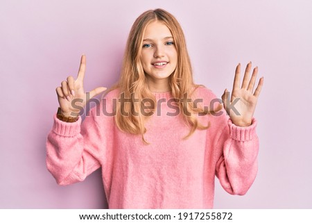 Beautiful young caucasian girl wearing casual clothes showing and pointing up with fingers number seven while smiling confident and happy. 