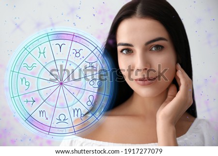Beautiful young woman and illustration of zodiac wheel with astrological signs on light background