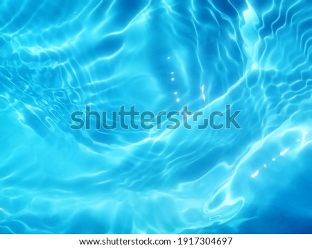 Blur​ abstract​ of​ surface​ blue​ water. Abstract​ of​ surface​ blue​ water​ reflected​ with​ sunlight​ for​ background. Blue​ sea. Blue​ water.​ Water​ splashed​ use​ for​ graphic​ design. Water​