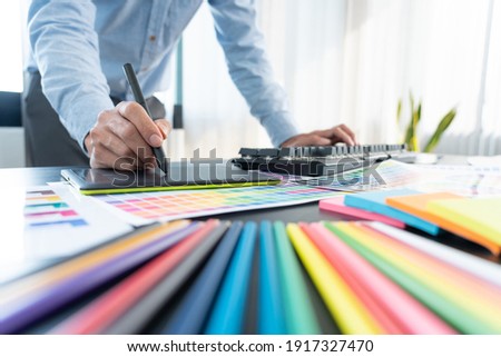 interior designer or creative graphic designer working on project architectural with colour samples with work tools and equipment for selection in office.