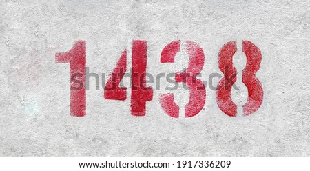 Red Number 1438 on the white wall. Spray paint.