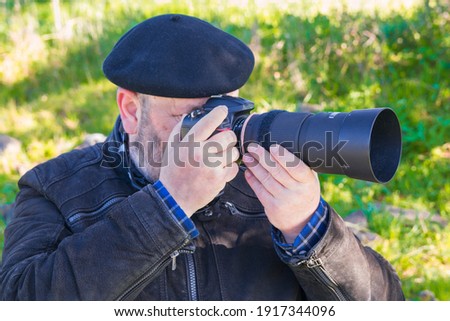 Close-up of an older man taking a picture in nature. Concept of enjoying in nature